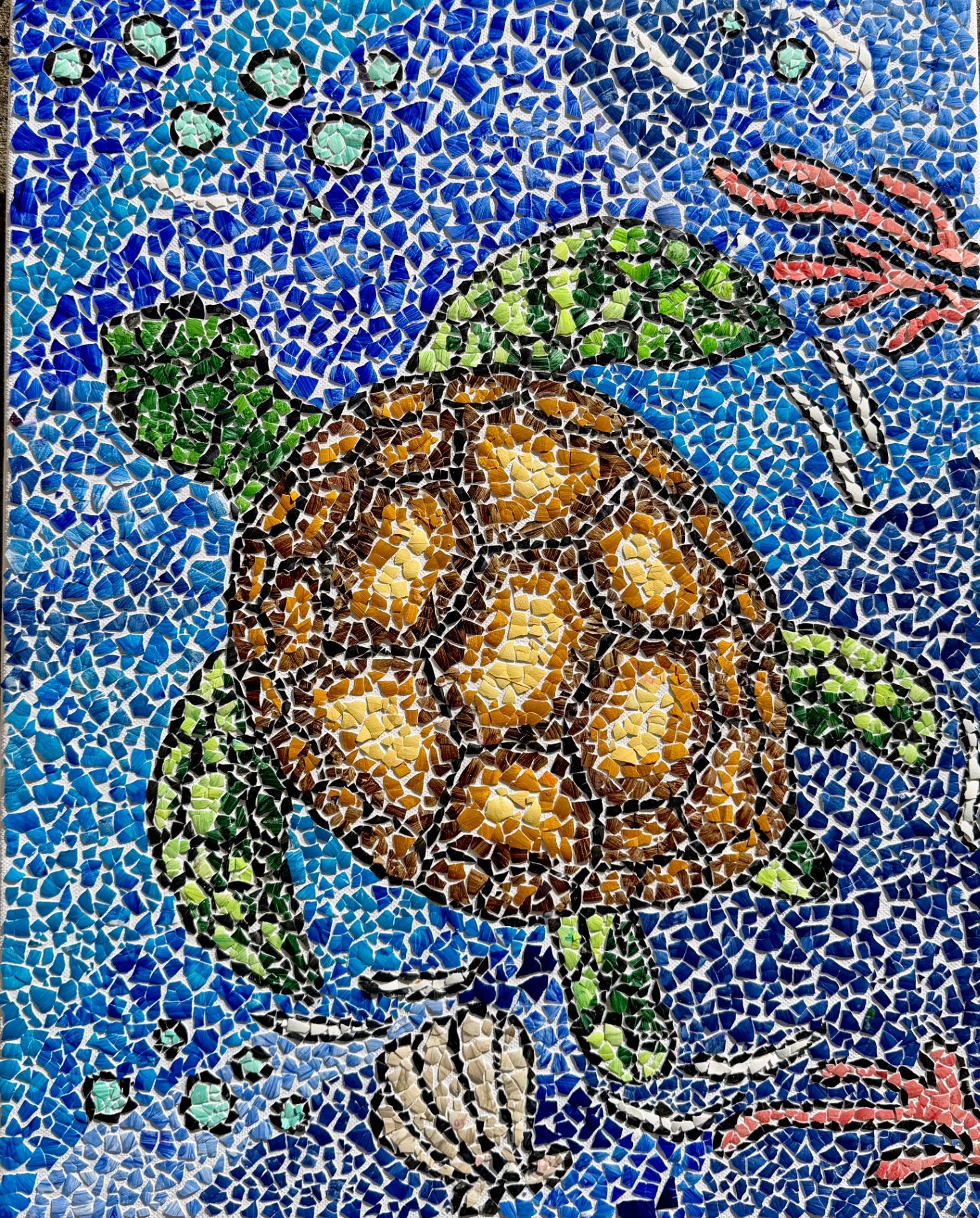 Eggshell mosaic of a sea turtle gliding through deep blue water with coral and bubbles